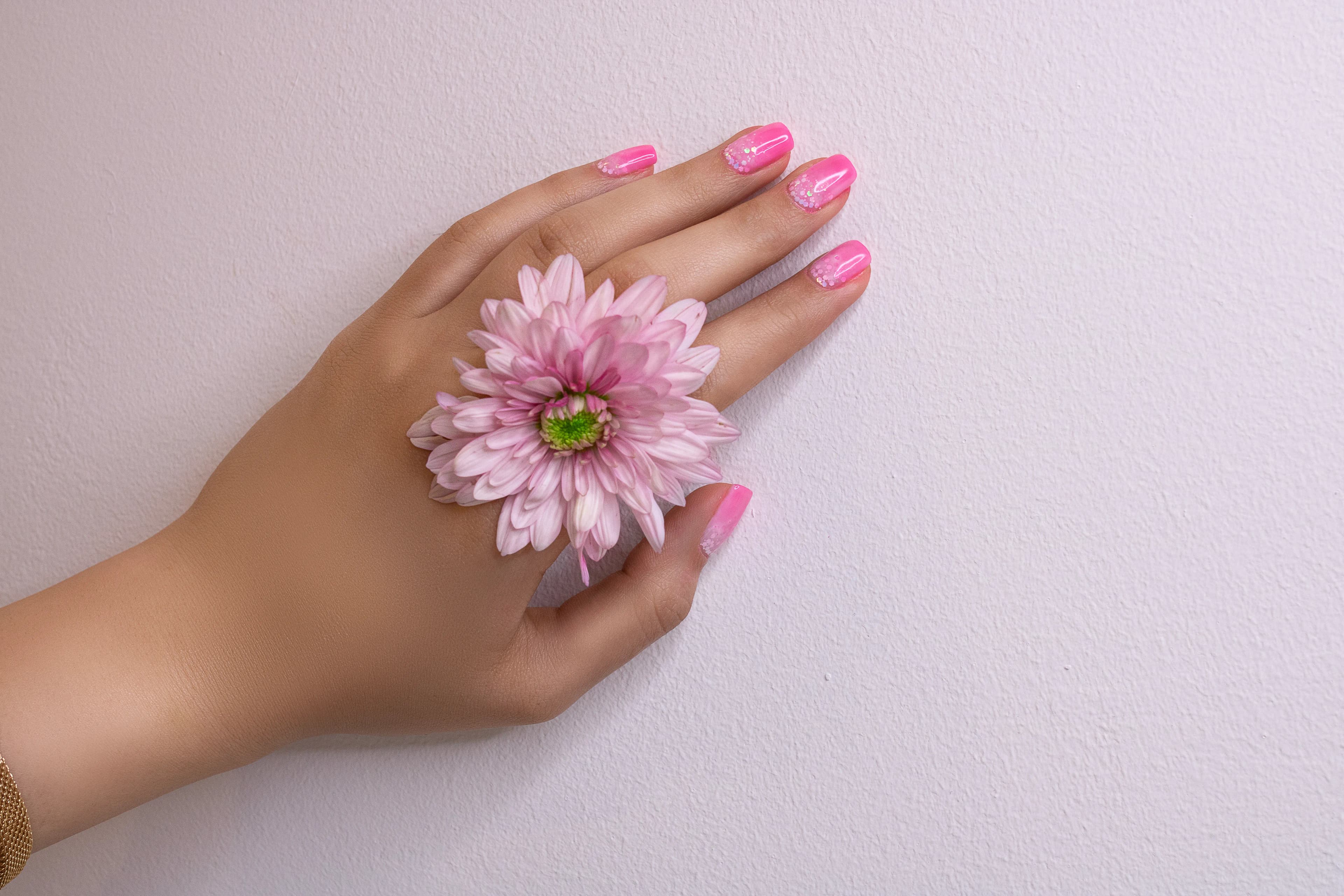 Soft pink nails holding a flower