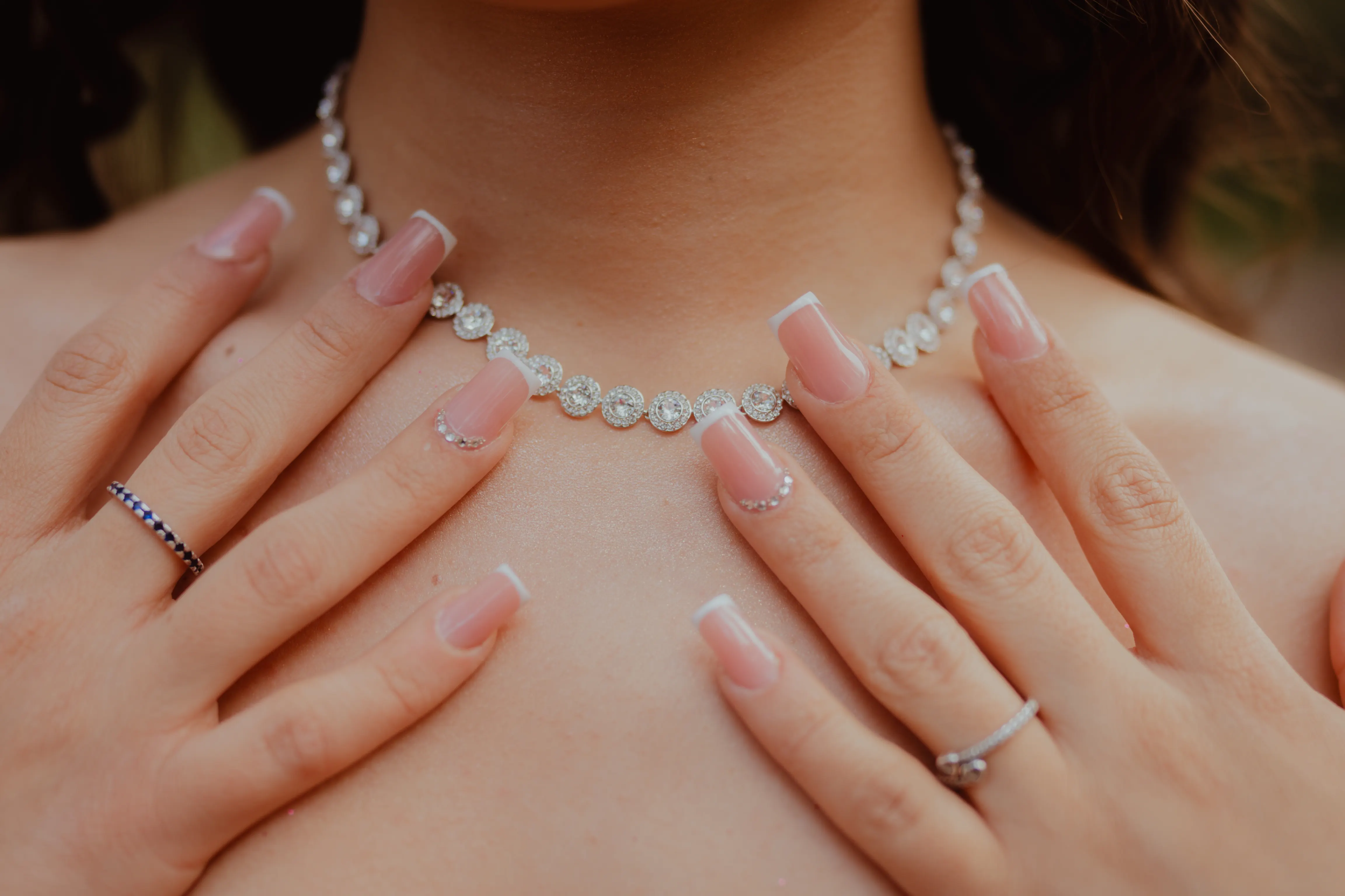 Hands with delicate nails and a diamond necklace