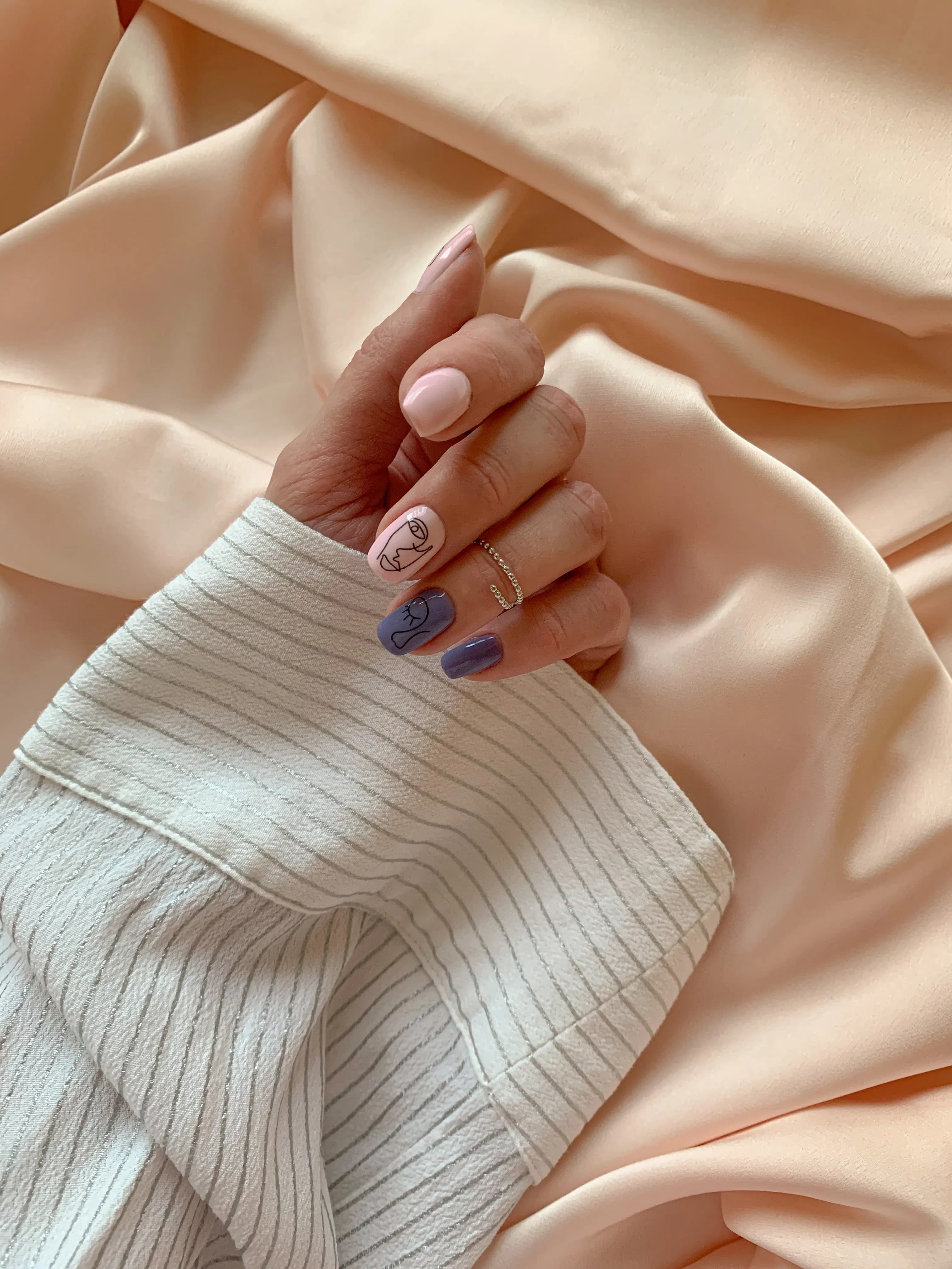 Hand with delicate nails on peach silk